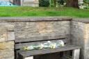 Flowers on the bench outside St James' Church where Alex Docherty was found.