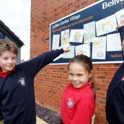 Competition winners Harrison, Cassie, and Olivia with their artworks at Bellway’s Ladden Garden Village's sales office