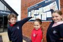 Competition winners Harrison, Cassie, and Olivia with their artworks at Bellway’s Ladden Garden Village's sales office