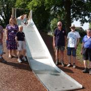 Councillors and staff by the new slide in Woodchester Park with local resident Isla