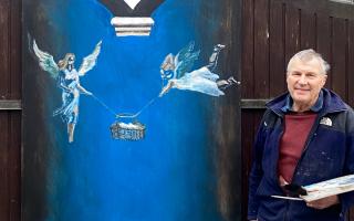 Angus Macaskill with his new festive painting on the gates of his home in Olveston
